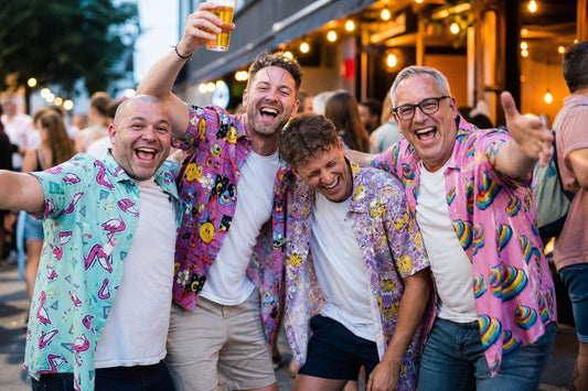 Group of British lads in bold Hawaiian shirts laughing on a summer night out