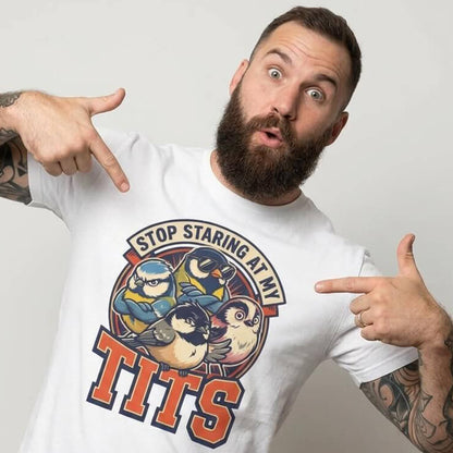 A bearded, tattooed man points at his white “Stop Staring at My Tits” Stag Do Tee with cartoon birds—an ideal funny stag do outfit and groom gift.