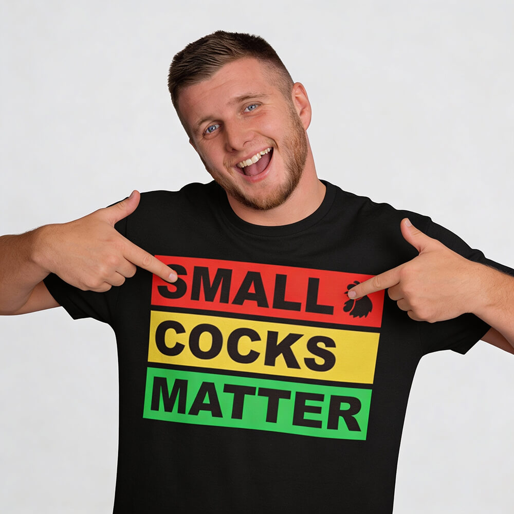 A smiling person points to their black Small Cocks Matter Stag Do Tee, which features bold red, yellow, and green block lettering—a funny and eye-catching stag party t-shirt that celebrates body confidence with humor.