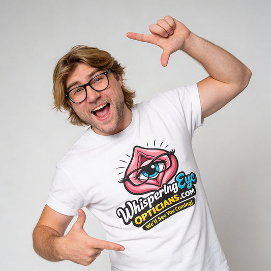 A smiling man with glasses points to his white Whispering Eye Opticians Logo Tee (We'll See You Coming!), featuring a cartoon eye in lips and the website text, displayed on a light gray background—ideal for cheeky stag dos.