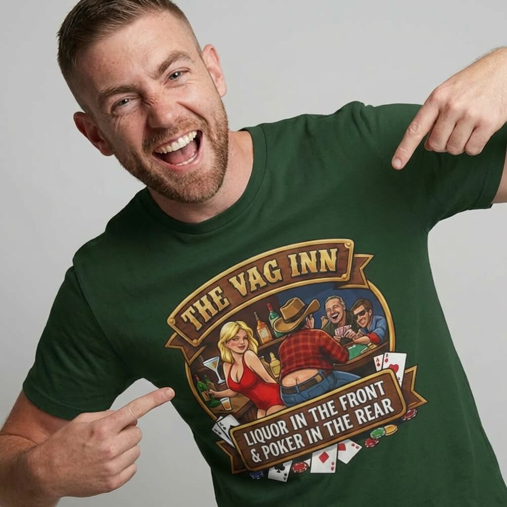 A smiling man points at his dark green "The Vag Inn Stag Do Tee," featuring a cartoon bar scene and the bold slogans "THE VAG INN" and "LIQUOR IN THE FRONT & POKER IN THE REAR"—a hilarious bachelor party shirt.