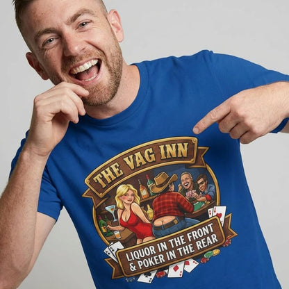 A smiling man points at his blue The Vag Inn Stag Do Tee, which features “THE VAG INN” above a cartoon bar scene and the funny slogan “LIQUOR IN THE FRONT & POKER IN THE REAR.”.