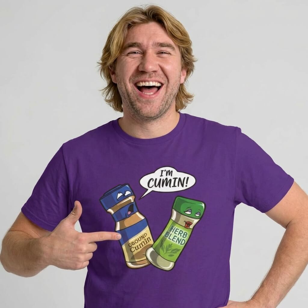 A smiling man in a purple shirt points to a cartoon spice bottle saying "IM CUMIN!" to a startled Herb Blend—making the "I’m Cumin!" Stag Do Tee the perfect funny choice for anyone after a spice-themed stag party shirt.