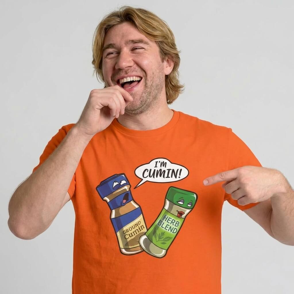 A smiling man points and laughs at his "I’m Cumin!" Stag Do Tee, featuring cartoon spice jars, ready for a memorable night out.
