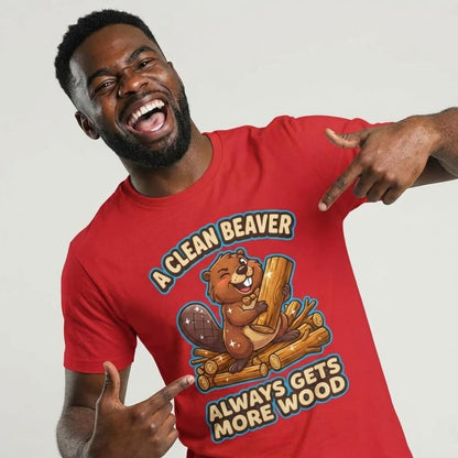A smiling man in a red "A Clean Beaver Always Gets More Wood" Stag Do Tee with a cartoon beaver holding logs points at the slogan while posing against a plain backdrop.