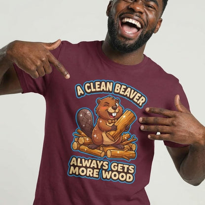 A smiling man points to his maroon "A Clean Beaver Always Gets More Wood" Stag Do Tee, a funny shirt with a cartoon beaver and logs—perfect for matching stag do outfits.