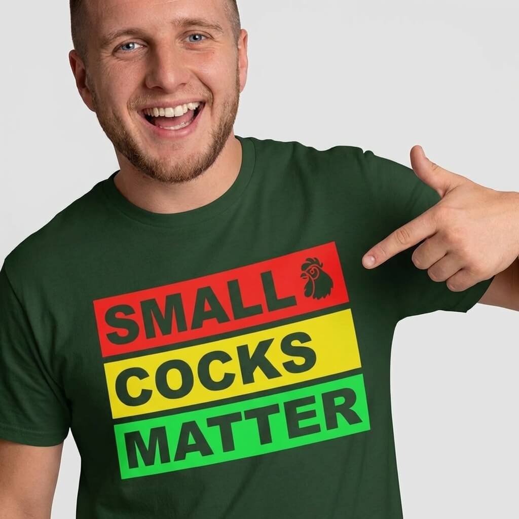 A smiling man in a green Small Cocks Matter Stag Do Tee points to the bold “SMALL COCKS MATTER” text with a cartoon rooster by "SMALL"—the perfect funny shirt for stag do celebrations.