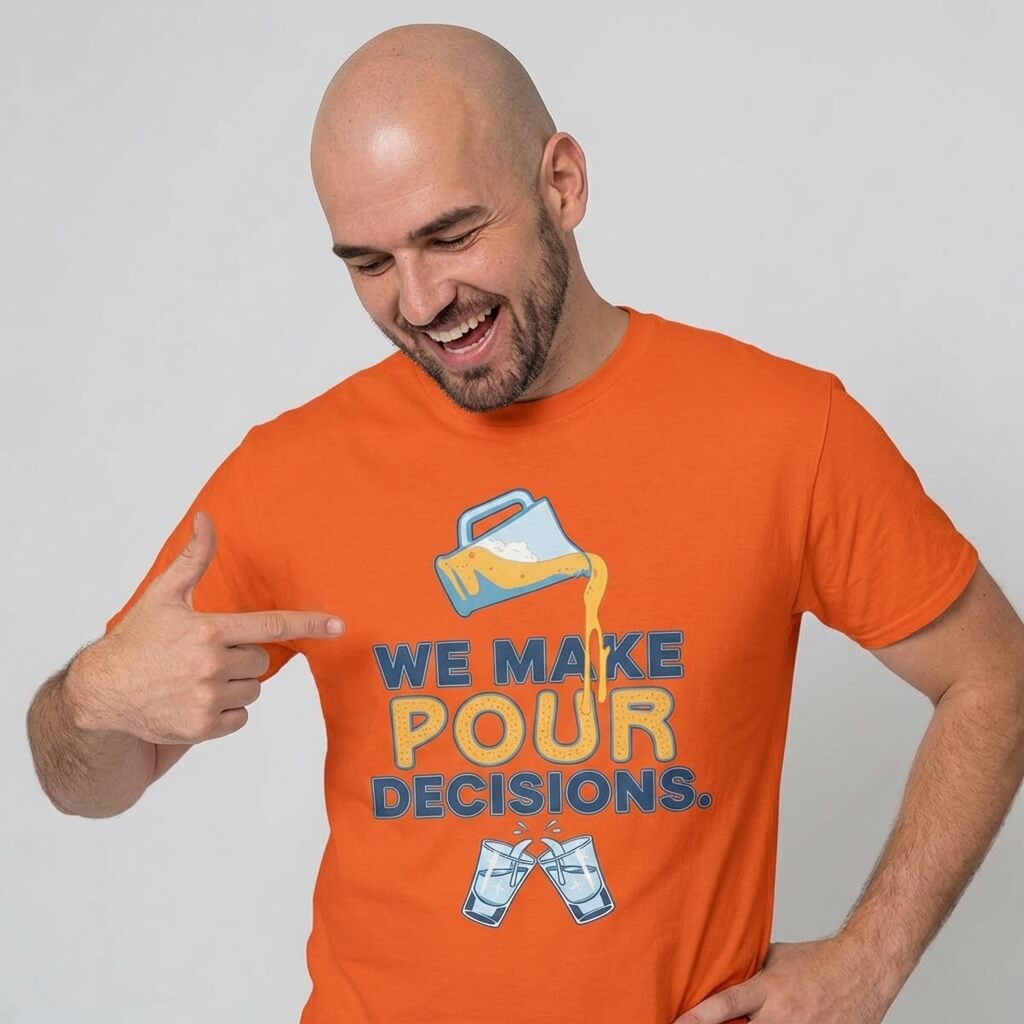 A smiling bald man in a We Make Pour Decisions Stag Do Tee points to his shirt, which features a pitcher pouring liquid over two clinking glasses with the slogan "We Make Pour Decisions.