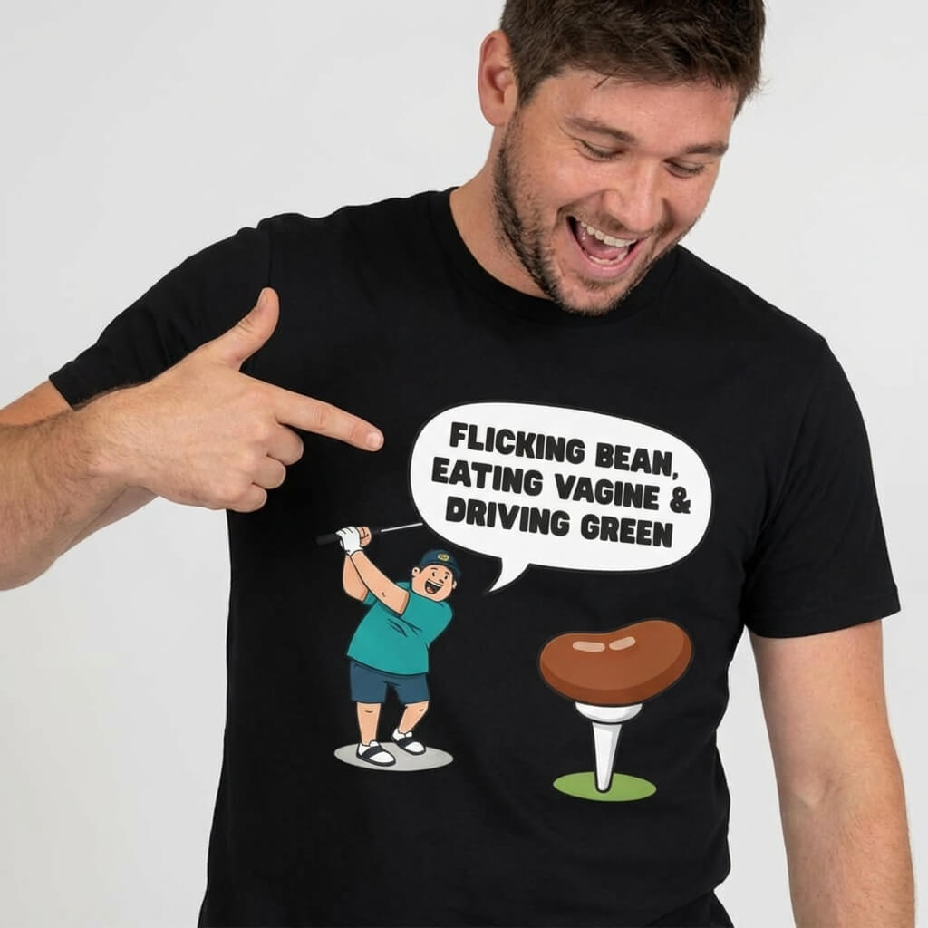 A man smiles and points at his "Flicking Bean, Eating Vagine & Driving Green" Tee, featuring a cartoon golfer with a speech bubble and an image of a bean on a golf tee.