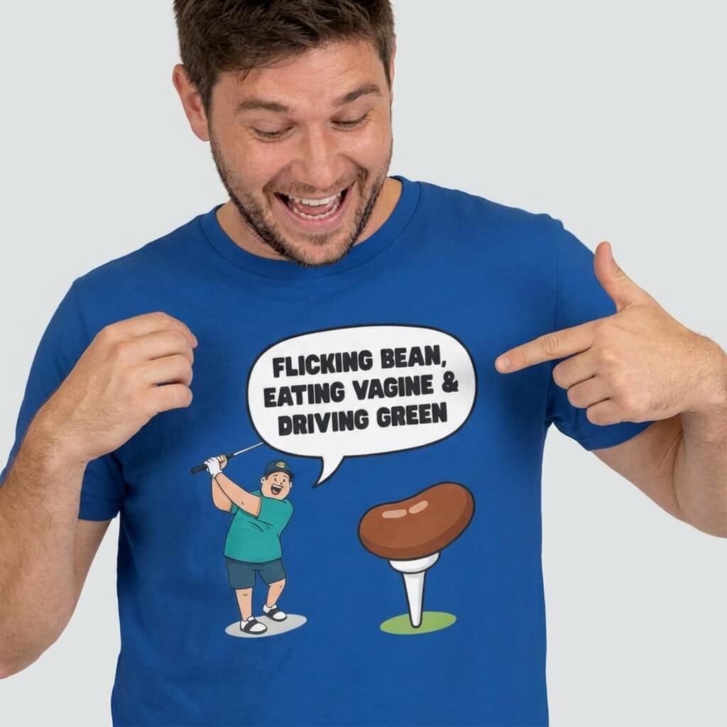 A smiling man in a blue "Flicking Bean, Eating Vagine & Driving Green" Tee points to its cartoon of a woman golfing with a bean and the cheeky speech bubble—perfect funny golf shirt for your next stag do!.