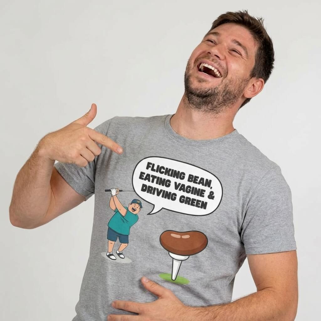 A man laughs and points at his "Flicking Bean, Eating Vagine & Driving Green" Tee, featuring a cartoon golfer and cheeky quote—a hilariously rude golf t-shirt perfect for getting laughs on the course.