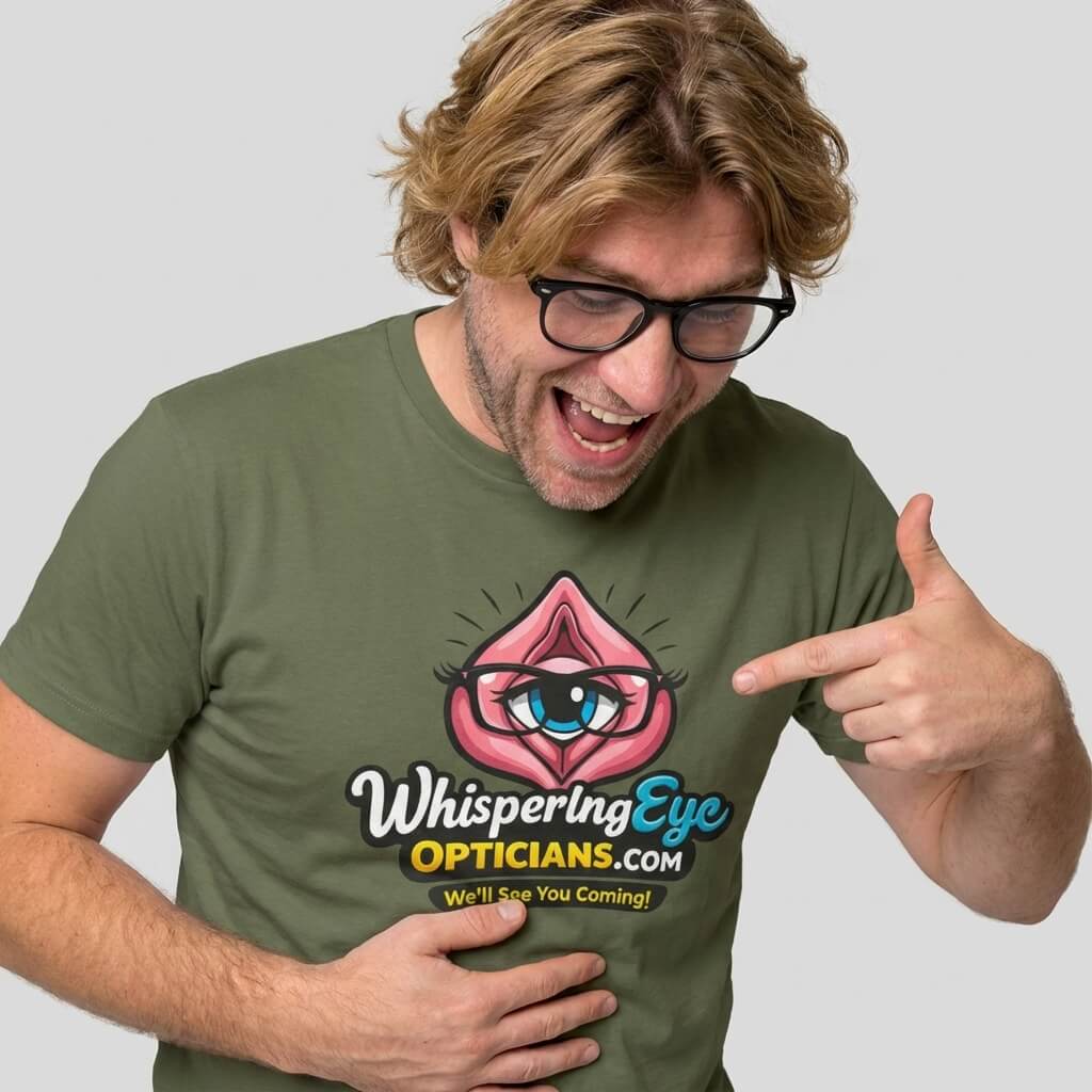 A blond man with glasses smiles and points at his green Whispering Eye Opticians Logo Tee ("We’ll See You Coming!")—a fun stag do t-shirt featuring a cartoon pink eye.