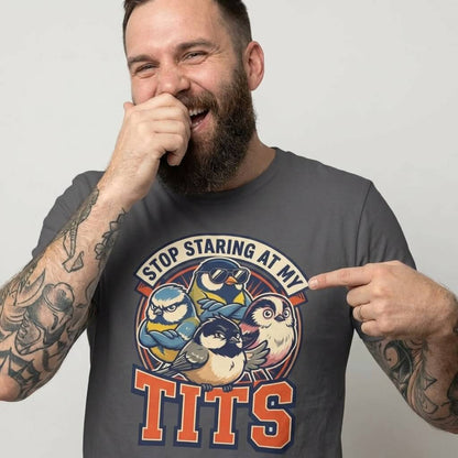 A bearded, tattooed man laughs and points at his “Stop Staring at My Tits” Stag Do Tee with cartoon birds—ideal for funny stag do outfits or as a cheeky groom gift.