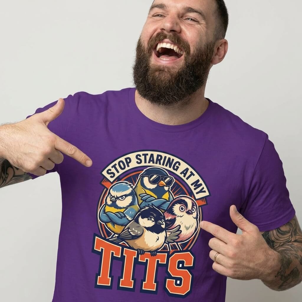 A bearded man laughs and points at his “Stop Staring at My Tits” Stag Do Tee, featuring cartoon birds—perfect for funny stag do outfits or as a unique gift for the groom.