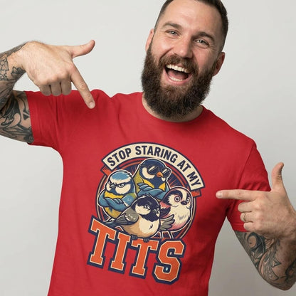 A bearded, tattooed man grins as he points at his “Stop Staring at My Tits” Stag Do Tee—featuring cartoon birds and bold text. This cheeky tee is perfect for funny stag do outfits or as a memorable gift for the groom.