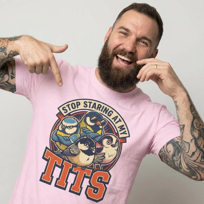 A bearded man in the “Stop Staring at My Tits” Stag Do Tee—featuring cartoon birds and bold text—smiles and points to his shirt. A hilarious stag do outfit or a unique groom gift!.
