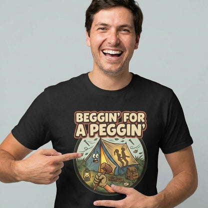 A smiling man points to his Beggin' for a Peggin' Camping Tee, featuring the slogan above a cartoon campsite with two shadowy figures in a tent—ideal as a festival outfit or cheeky camping gift.