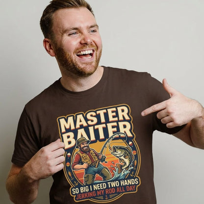 A bearded man smiles and points to his Master Baiter Rude Fishing Tee, which shows a cartoon fisherman catching a big fish and the phrase: MASTER BAITER: SO BIG I NEED TWO HANDS, JERKING MY ROD ALL DAY.