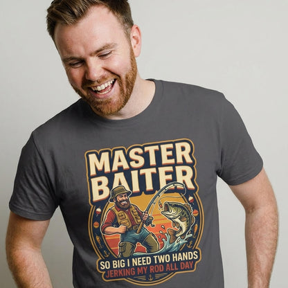 A bearded man smiles in the gray Master Baiter Rude Fishing Tee, featuring a cartoon fisherman and the text "So big I need two hands jerking my rod all day"—an ideal funny fishing shirt.