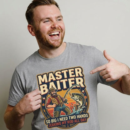A smiling man points to his gray Master Baiter Rude Fishing Tee, which features a cartoon and the funny text: “MASTER BAITER, so big I need two hands, jerking my rod all day”—an ideal rude fishing gift.