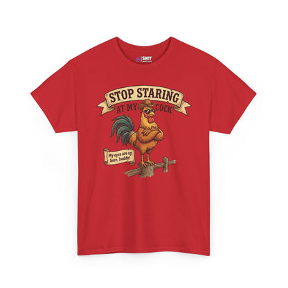 The Stop Staring at My Cock Stag Do Tee is a red t-shirt featuring an illustrated rooster on a fence, bold banners, and witty messages—perfect for stag parties or as a funny groom shirt.