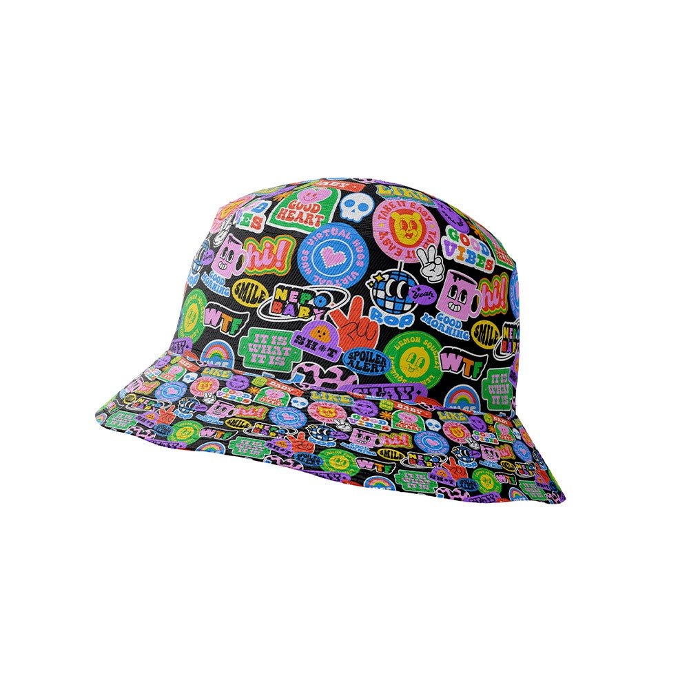 The Retro Sticker Bucket Hat features bright, cartoon-style patches and stickers—words, symbols, hearts, and smiley faces—on a black background for a playful 90s-inspired look.