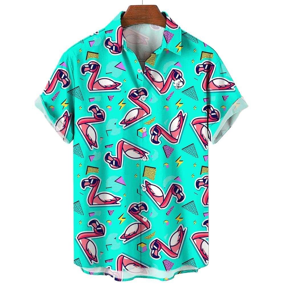 The Flamingo Fandango Shirt is a short-sleeve top with a vibrant turquoise background, playful pink flamingos, and geometric shapes in yellow, magenta, and blue. This novelty bird shirt is displayed on a wooden hanger.