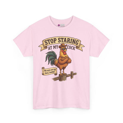 The Stop Staring at My Cock Tee is a light pink shirt with a cartoon rooster in sunglasses on a fence. It features the text "Stop Staring at My Cock" above and "My eyes are up here, buddy!" below—great for stag parties.
