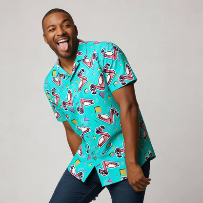 A smiling man playfully sticks out his tongue while wearing the vibrant Flamingo Fandango Shirt and dark jeans, standing against a plain light gray background.
