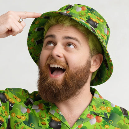 A bearded man with dyed green hair smiles and points at his head. He wears a St Patrick’s Day Bucket Hat and a matching shirt with cartoon coins and festive symbols.