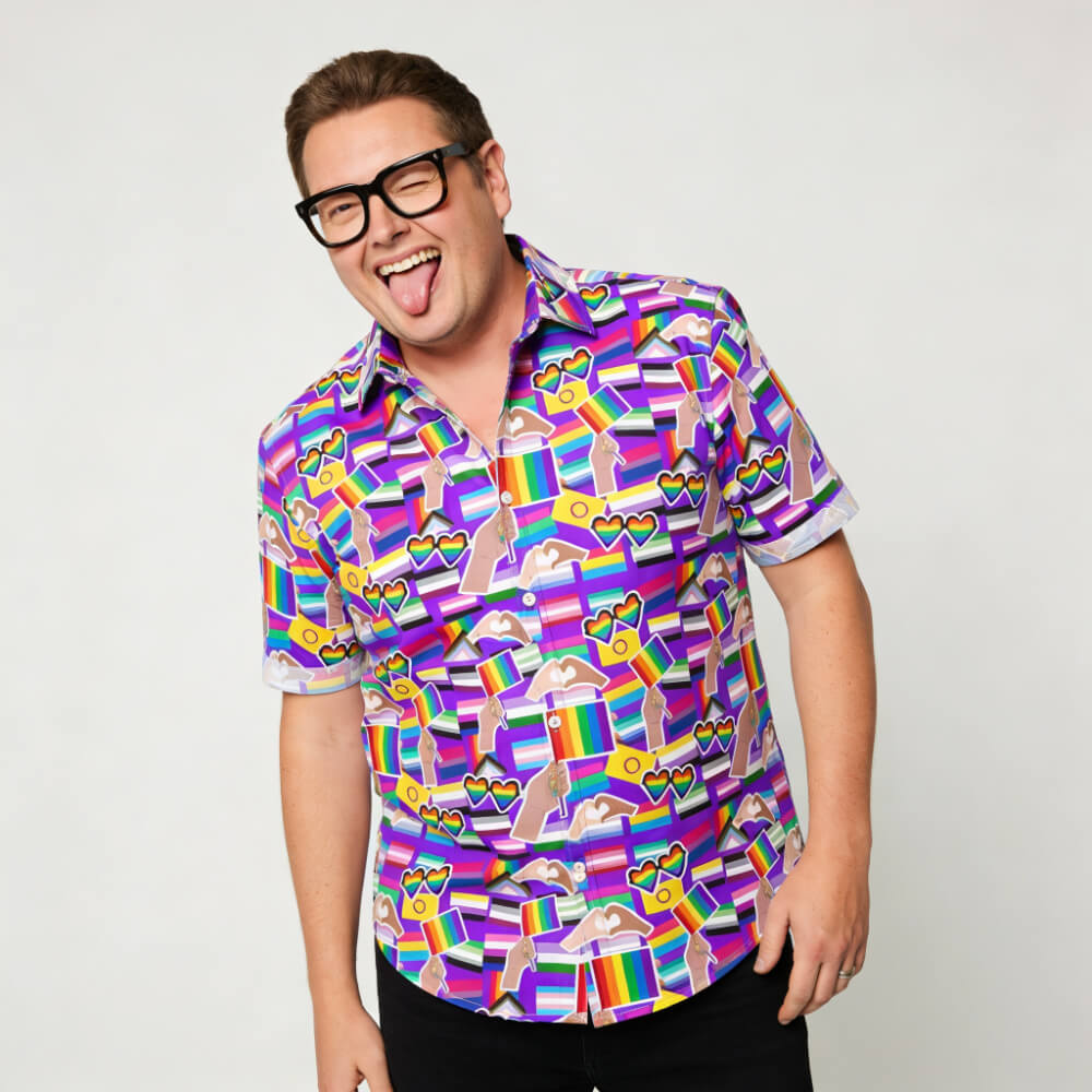 A person with short hair and black glasses smiles and sticks out their tongue, wearing the LGBTQ Pride Shirt featuring rainbows, hearts, and clouds on a white background.
