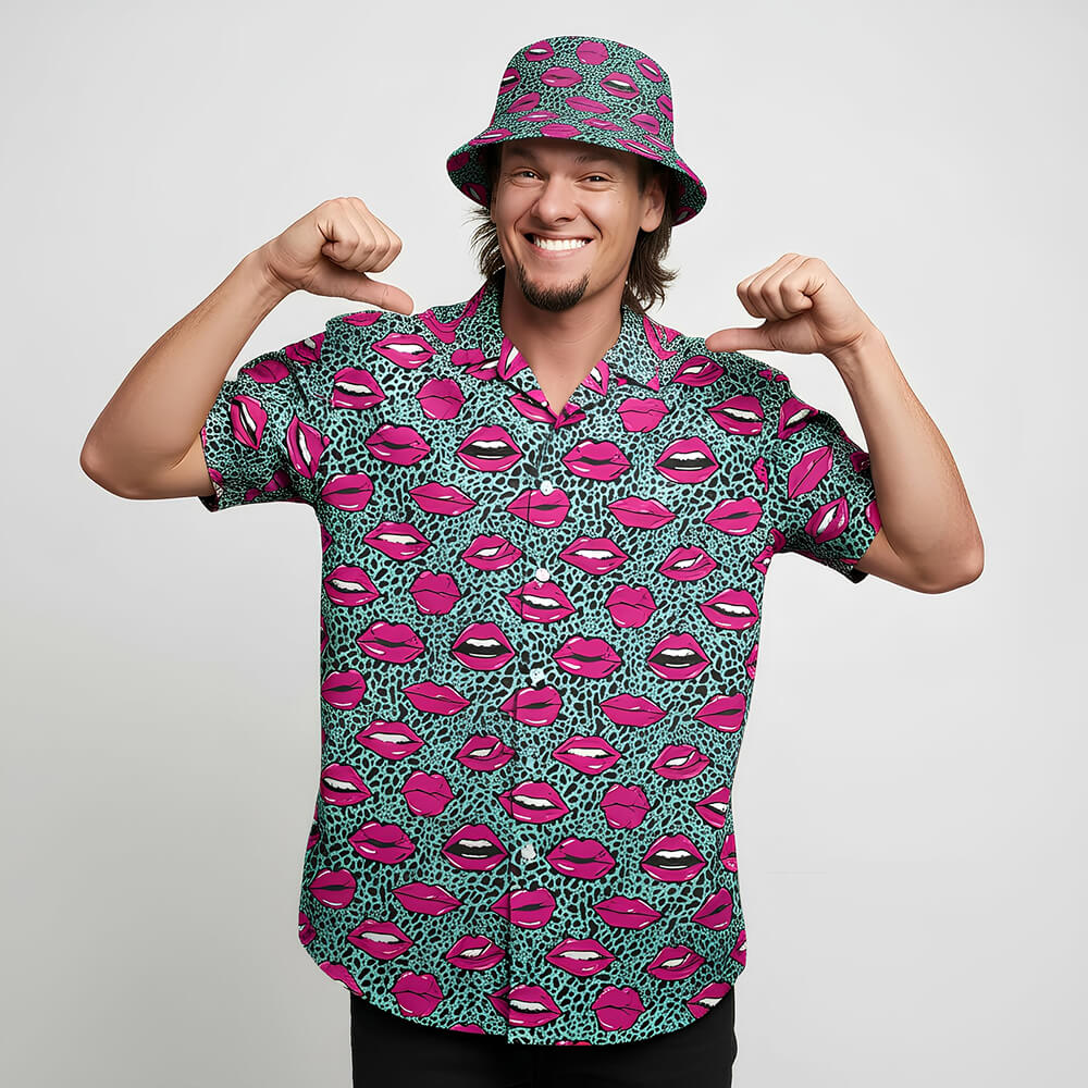 A cheerful man in a matching shirt and bucket hat with vibrant lips print proudly shows off his Leopard Kiss Bad Shirt against a plain white background—a true statement piece.