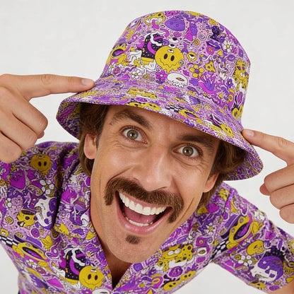 A smiling man with a mustache points at his Magical Psychedelic Bucket Hat, which matches his shirt. The hat features yellow smiley faces and whimsical patterns—perfect for festival fashion. The background is plain white.