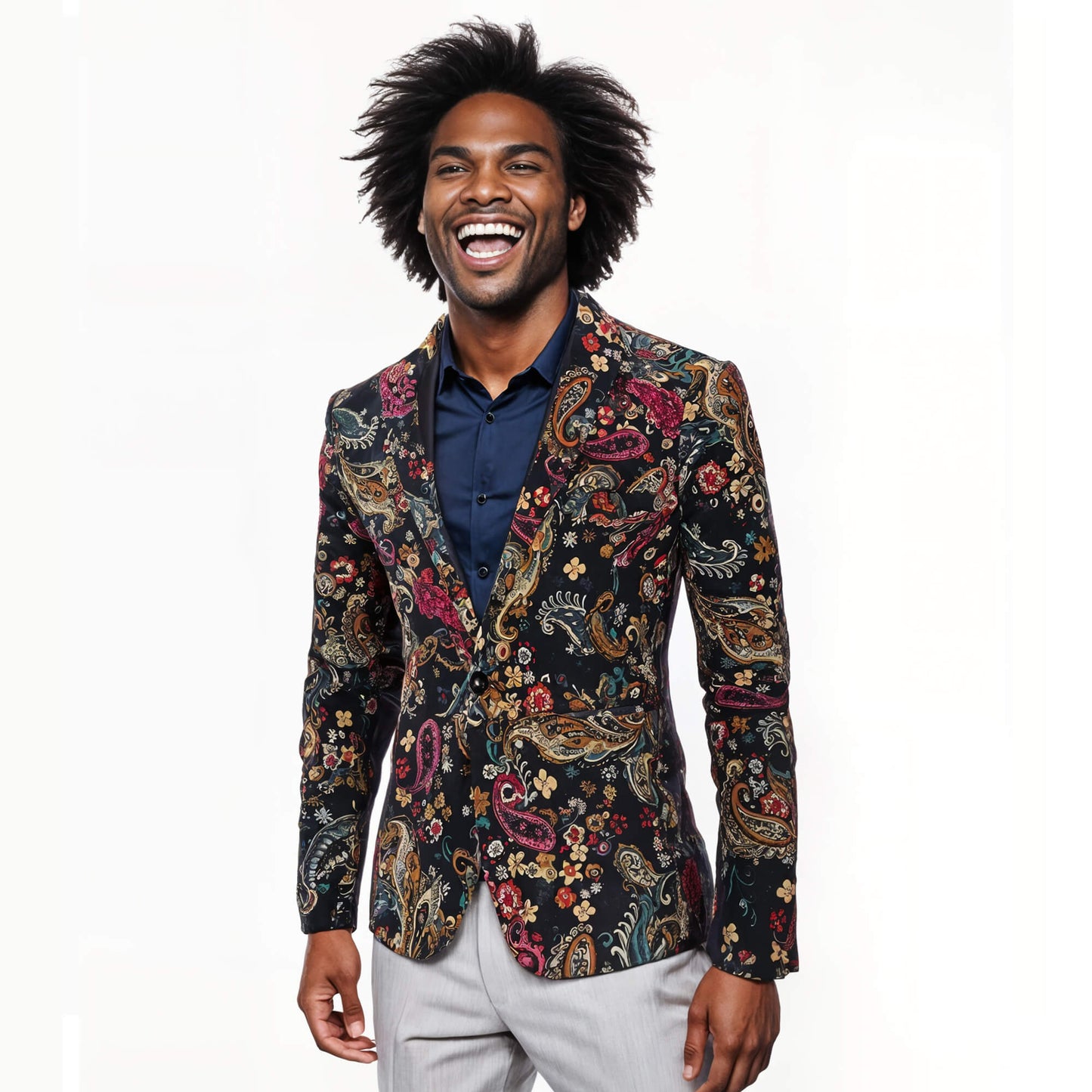 A smiling man with an afro, dressed in a navy shirt, light gray pants, and the Navy Floral Blazer, stands against a plain white background.