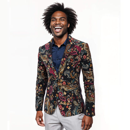 A smiling man with an afro, dressed in a navy shirt, light gray pants, and the Navy Floral Blazer, stands against a plain white background.