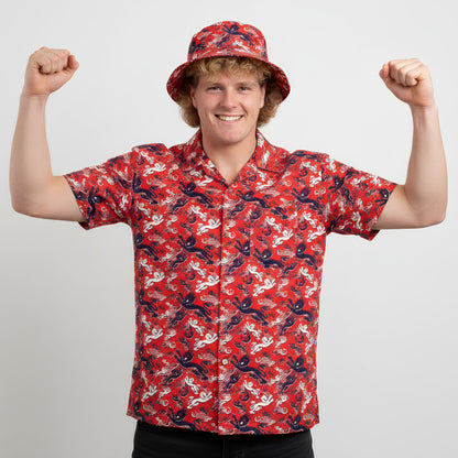 A smiling person wearing the Red England FC Hawaiian Shirt raises both arms in a flexing pose against a plain white background.