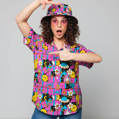 A surprised person wearing bright pink glasses, a vibrant smiley-face bucket hat, and the Trippy Space Shirt with psychedelic magenta patterns poses energetically against a plain background.