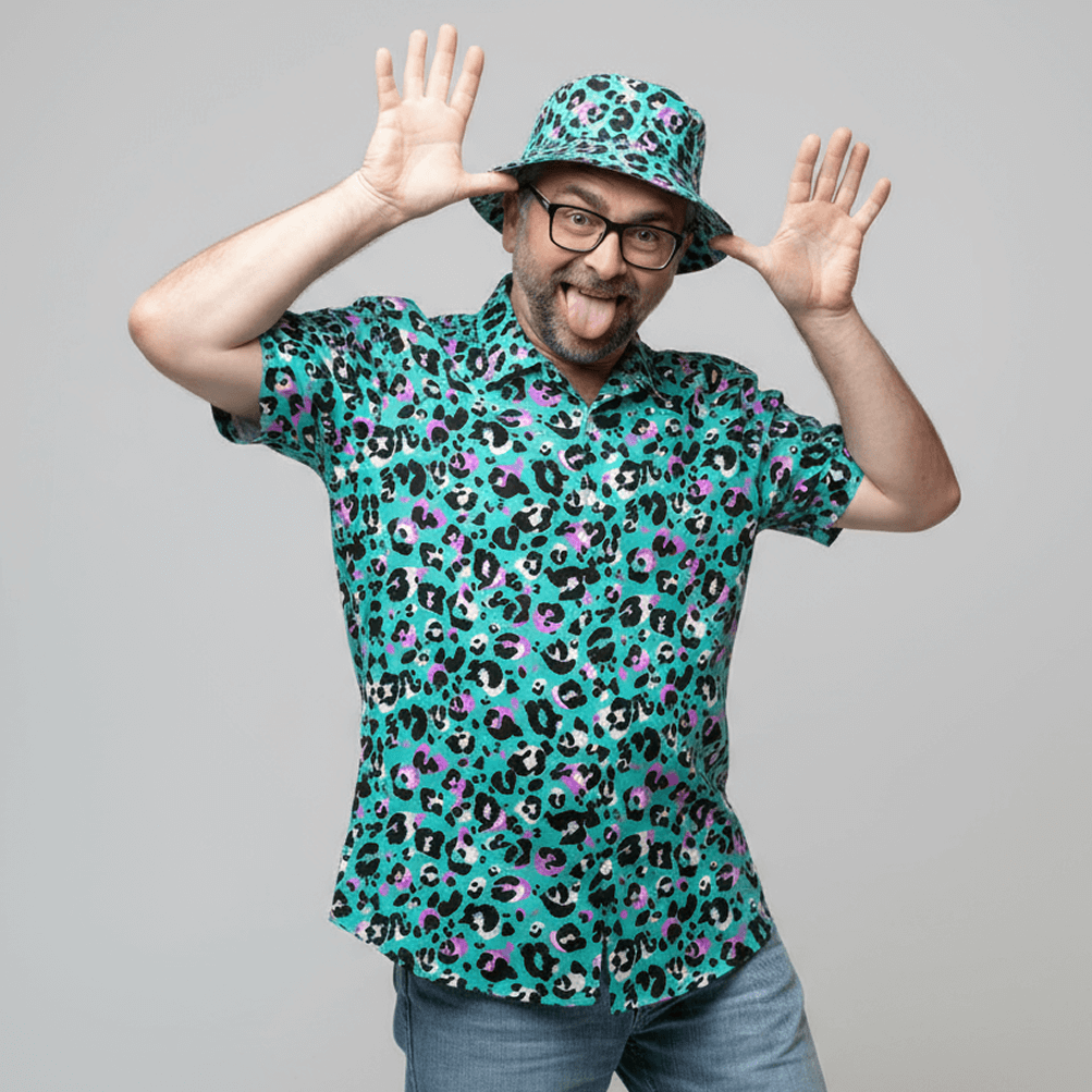 Man wearing the Turquoise Tempest Leopard Print Shirt and matching bucket hat on a grey background doing a silly pose 