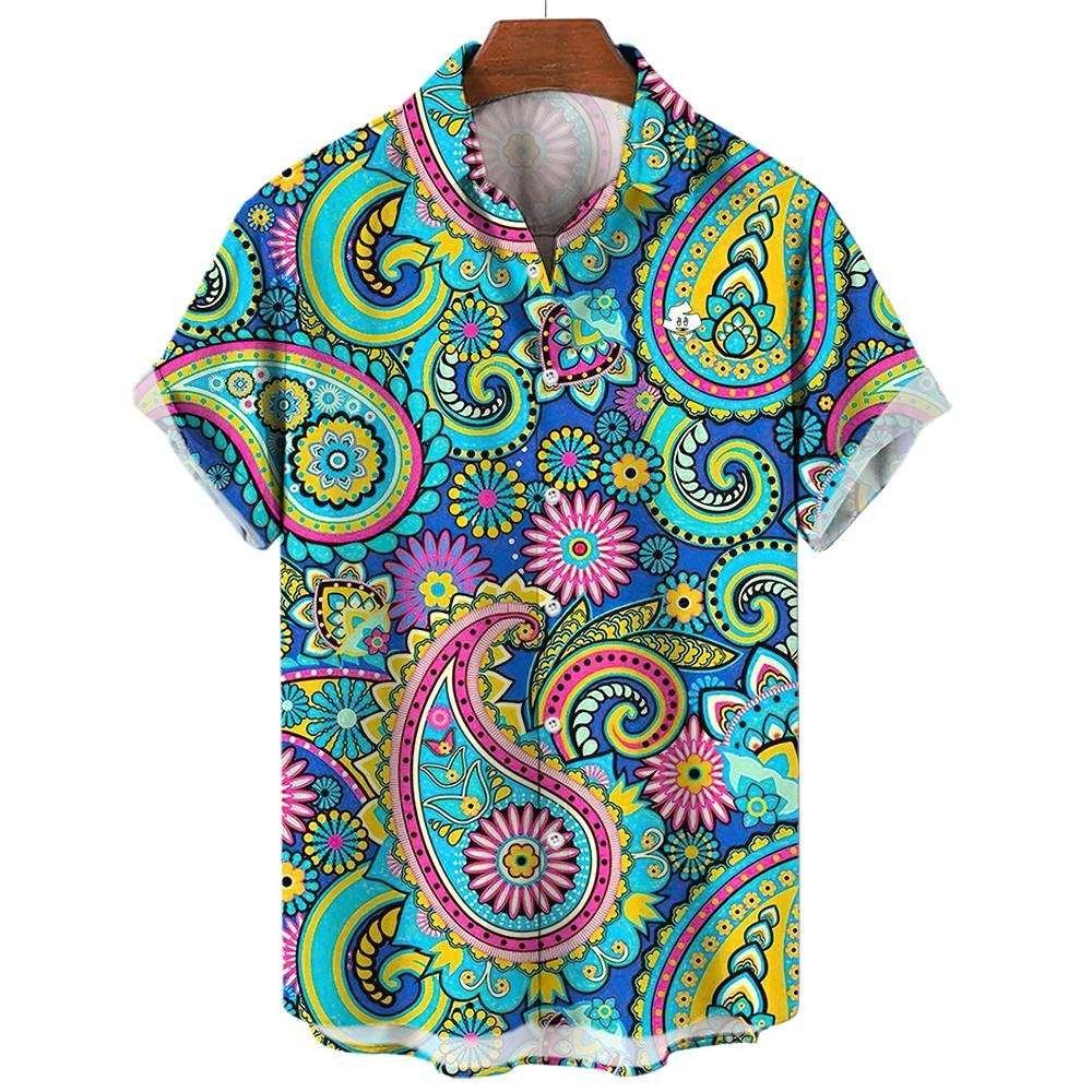 The Psychedelic Explorer Shirt is a short-sleeve button-up featuring a vibrant paisley and floral print in bright blue, yellow, pink, and green, shown on a wooden hanger against a white background.